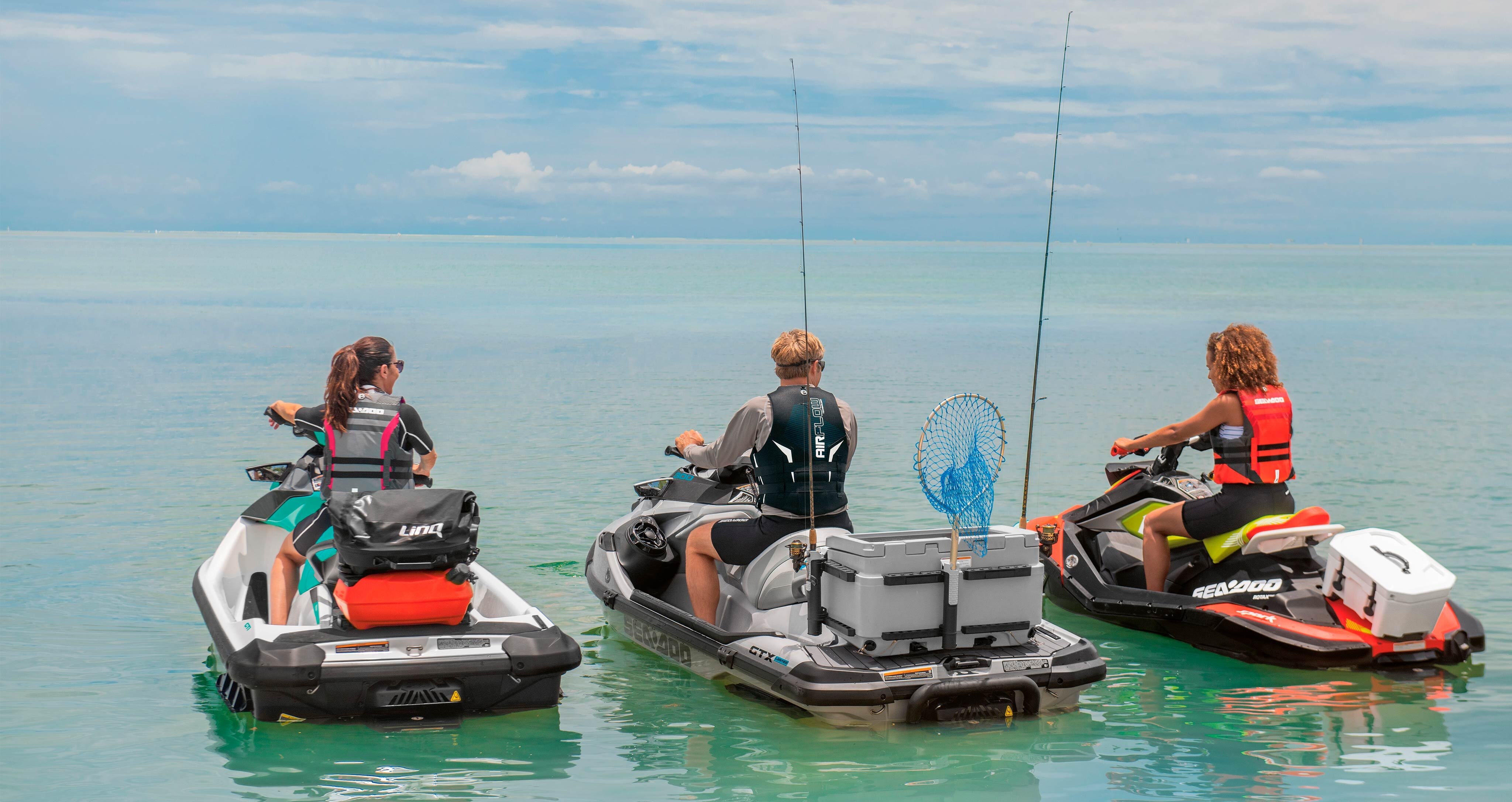 Three friends  with fishing equipment riding their Sea-doo personal watercraft