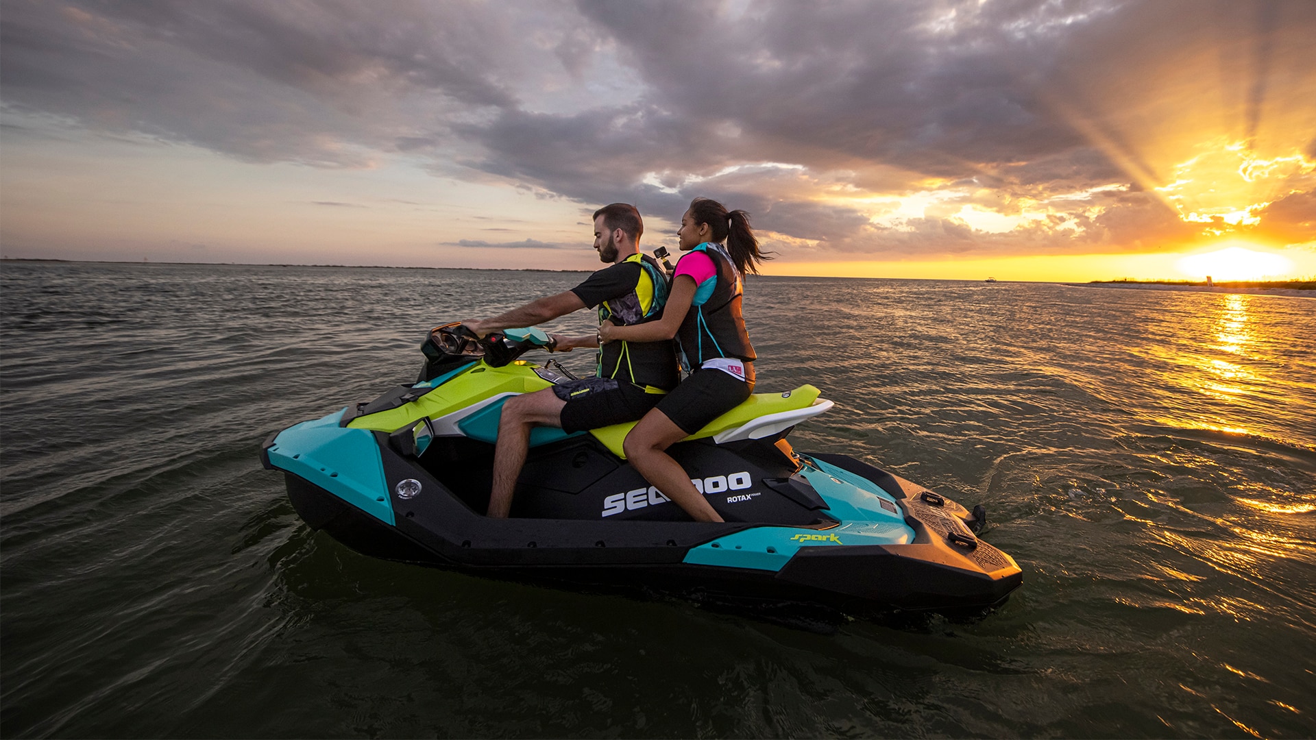 Couple idling by in the middle of a body of water on a Sea-Doo Spark PWC