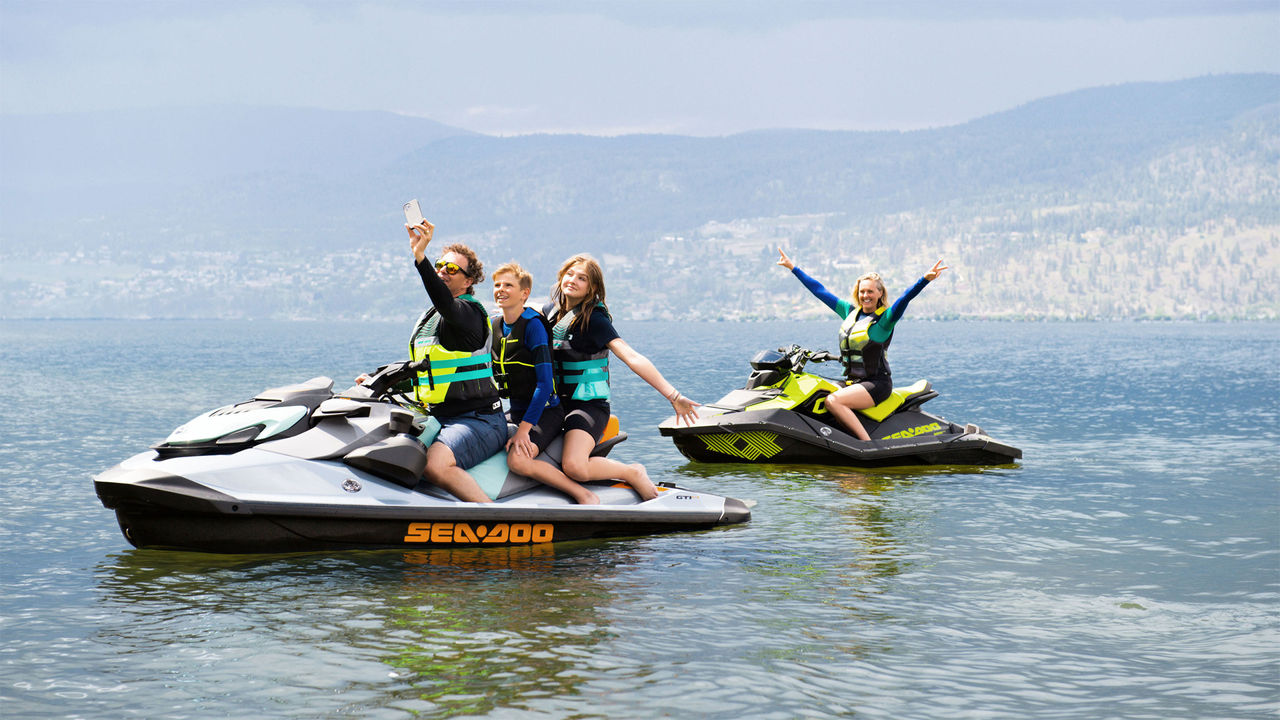 Family posing for a photo on Sea-Doo products.