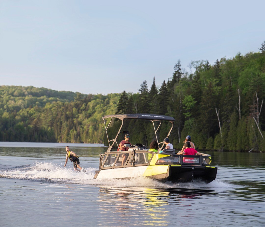 Group of friends towing a wakeboarder behind their Sea-Doo Switch pontoon