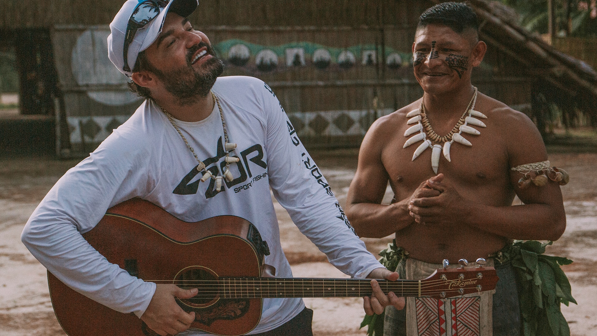 Fernando tocando violão com índio da Amazônia