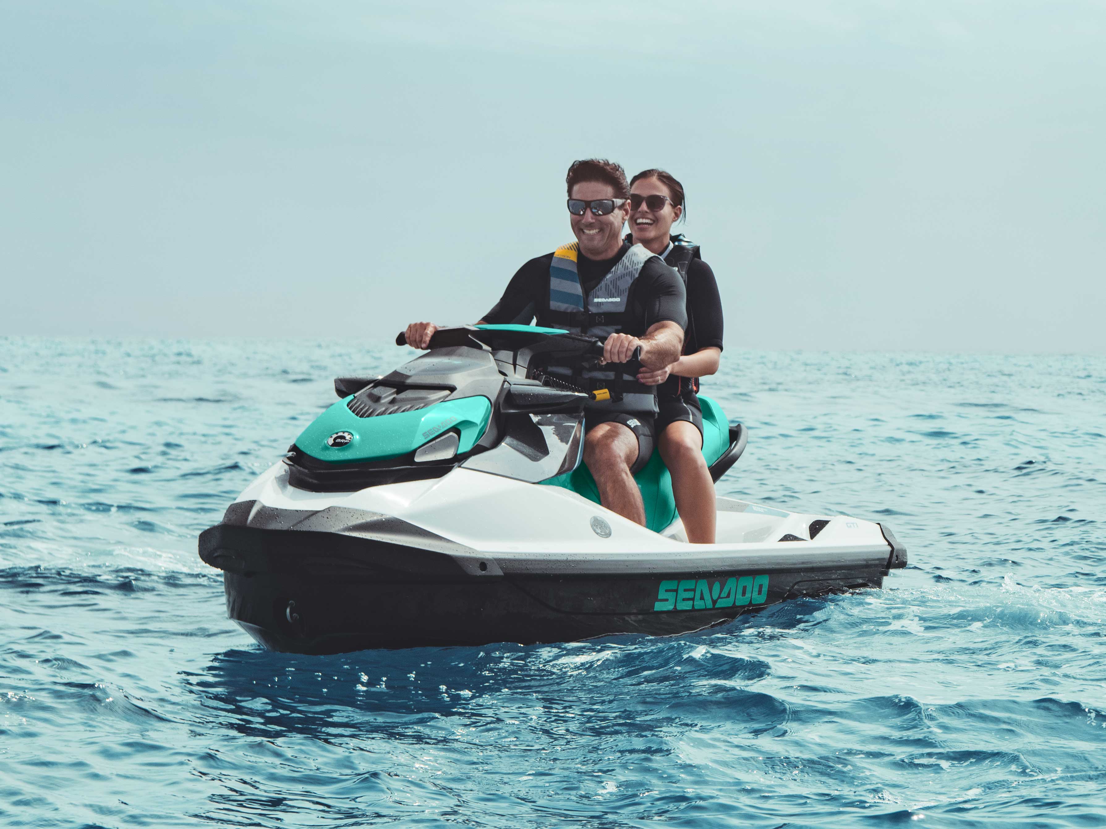 Couple riding a Sea-Doo GTI with Polytec Gen II hull