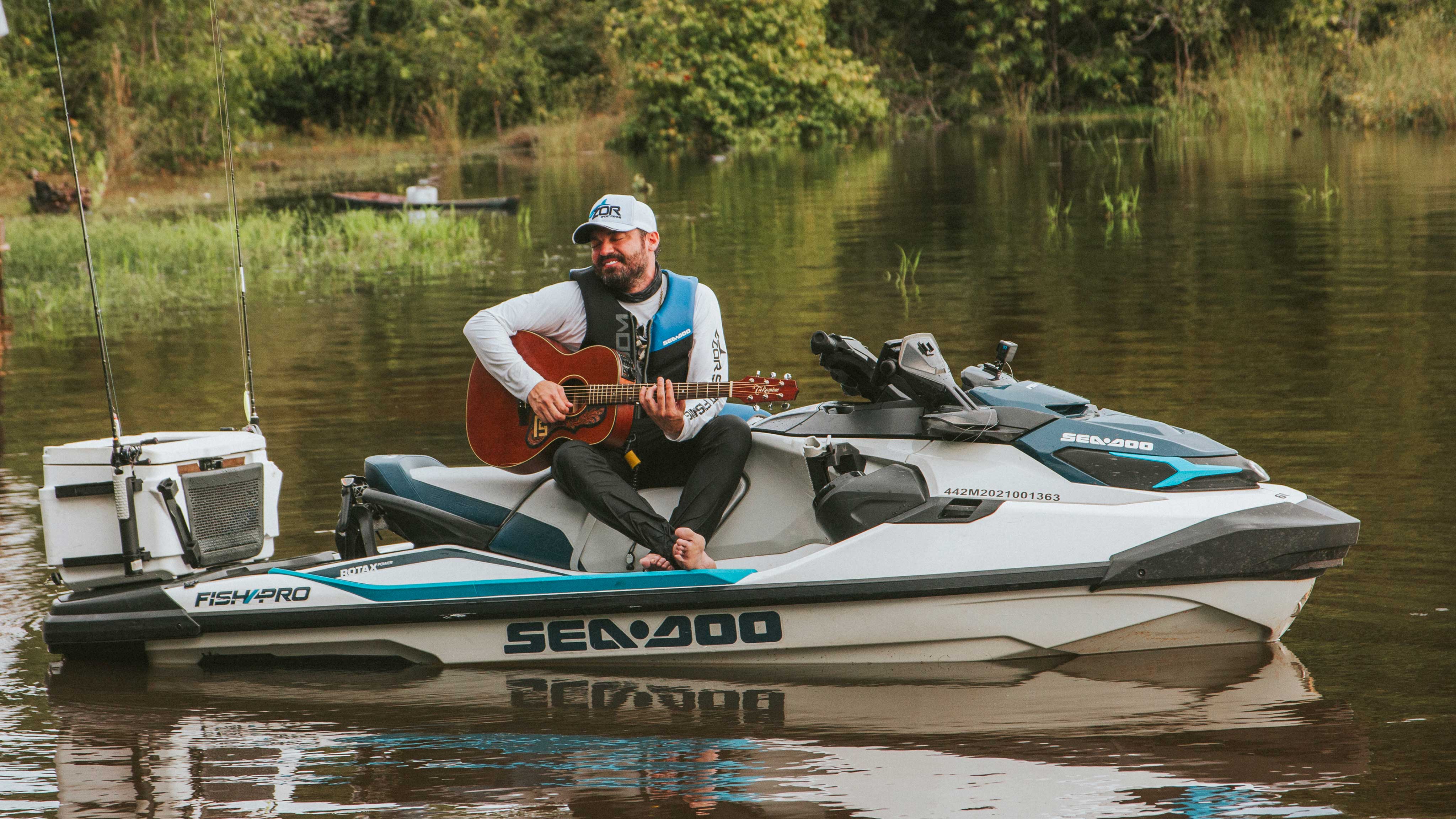 Fernando Zor qui joue de la guitare sur un Sea-Doo en Amazonie