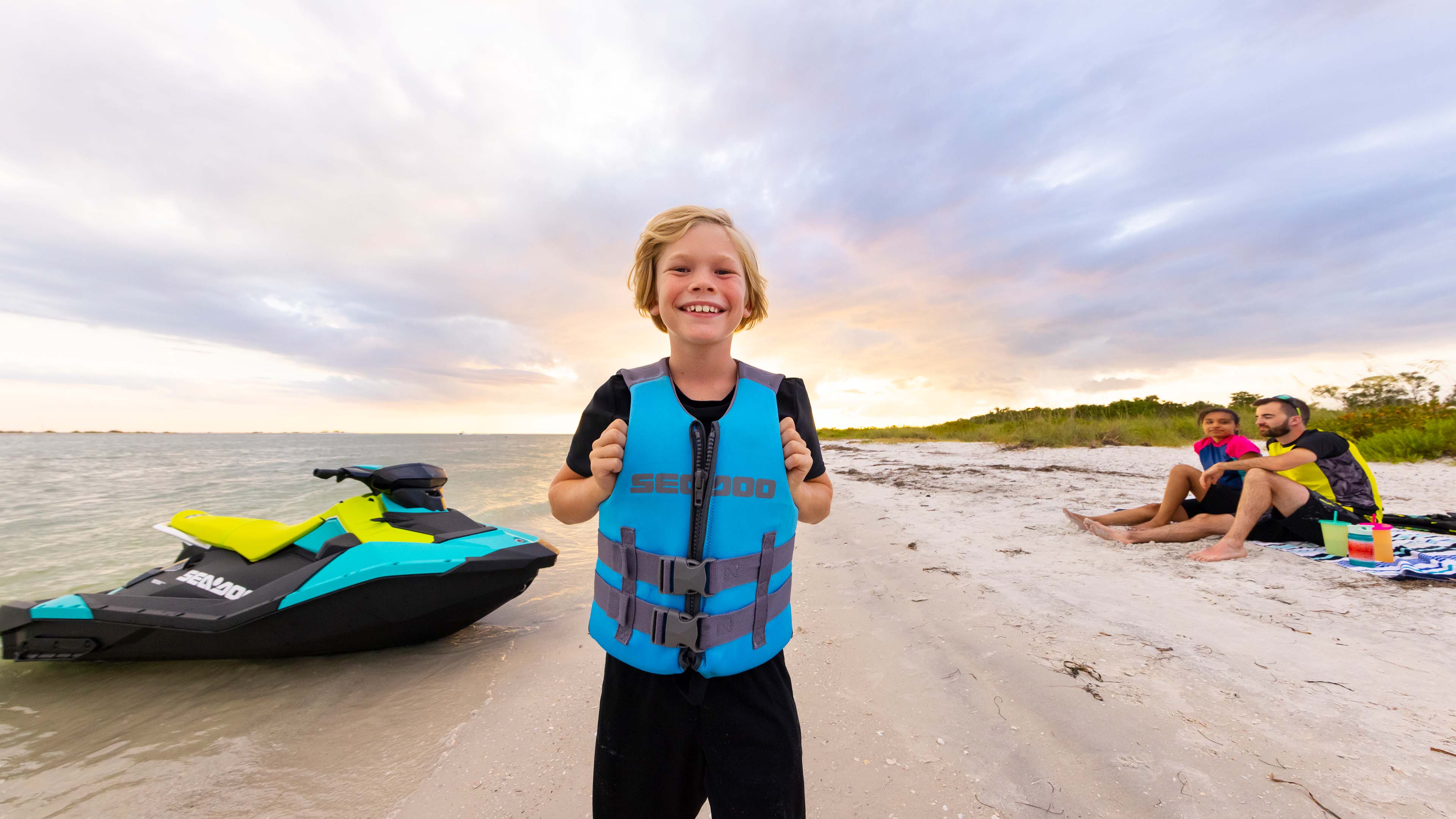 Kid with a Sea-Doo lifevest smiling