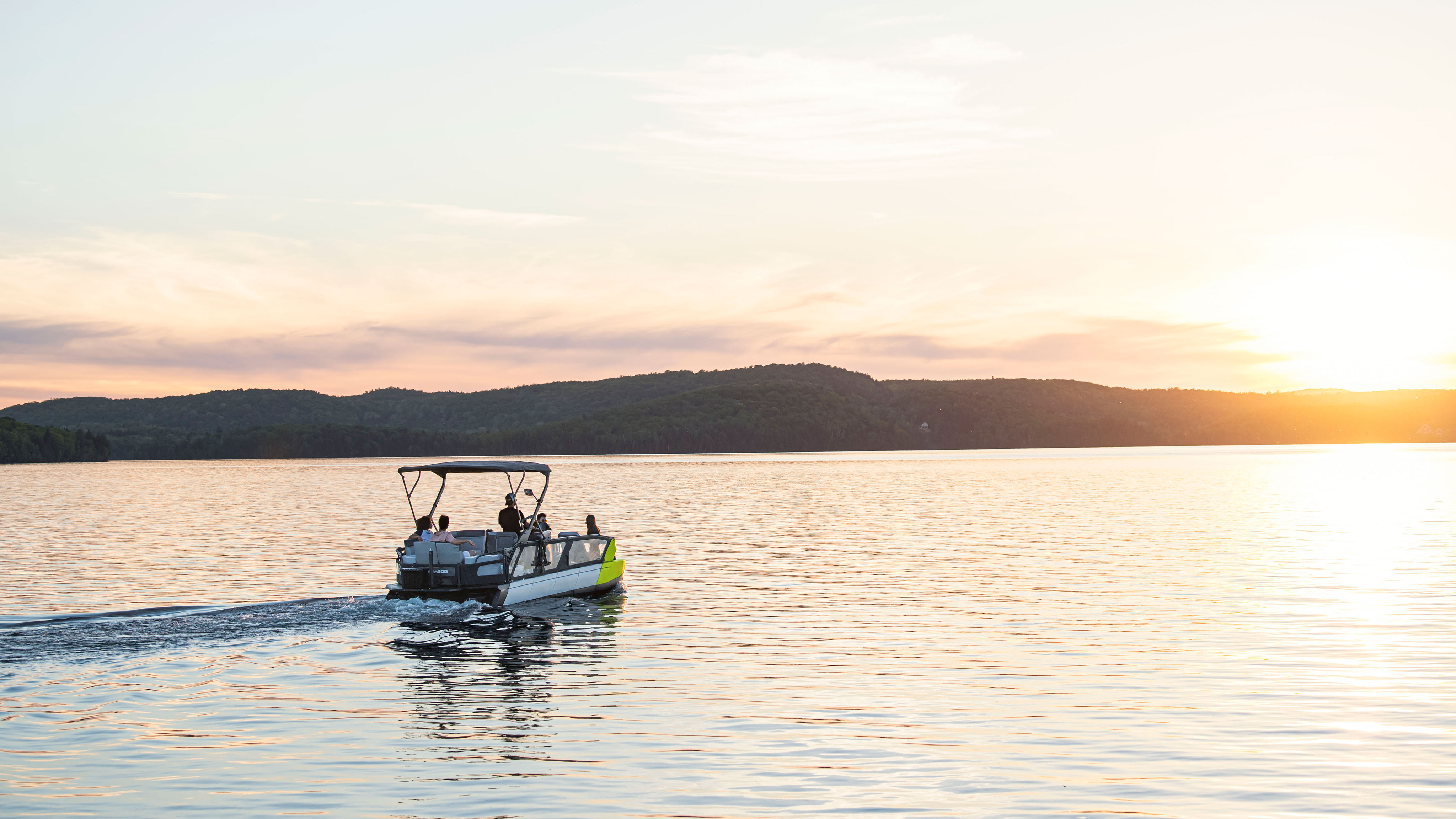 Sea-Doo SWITCH pontoon cruising on a lake at sunset 