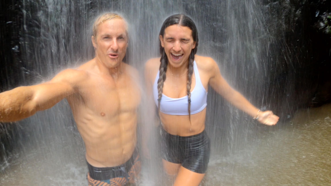 Chris Farro and his girlfriend ridding under a waterfall in Hawaii