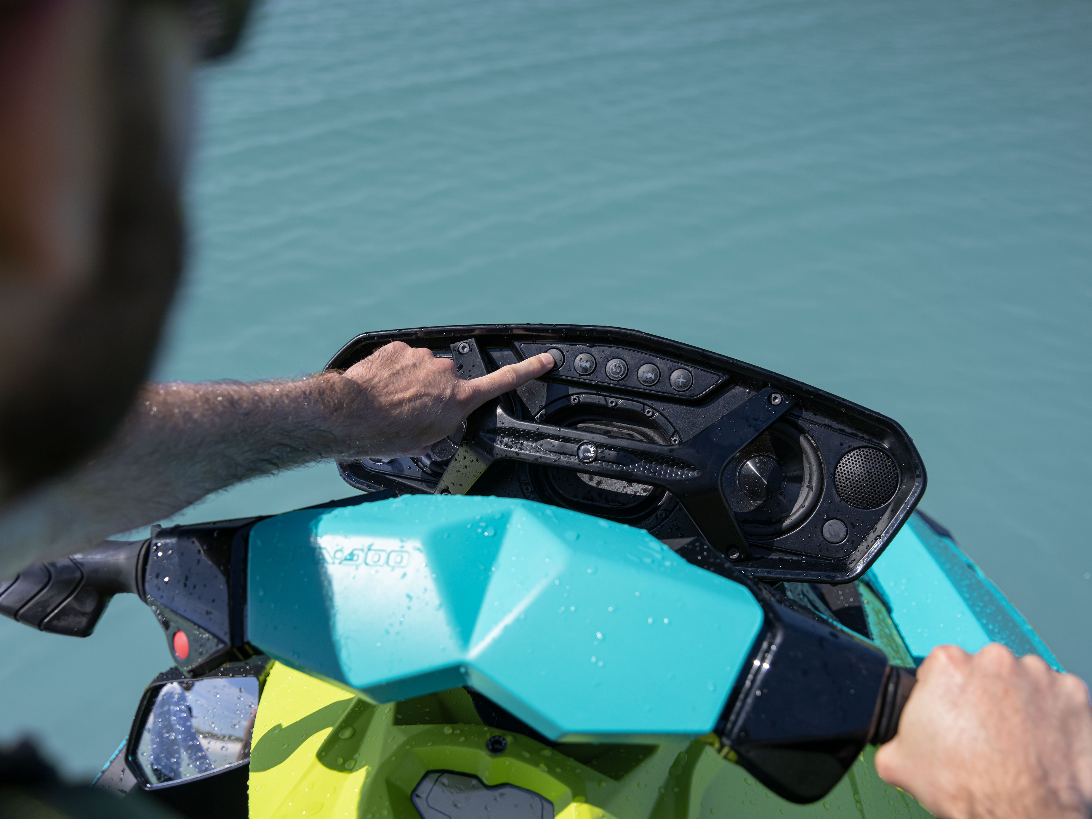 Closeup of a person using the audio system on a Sea-Doo