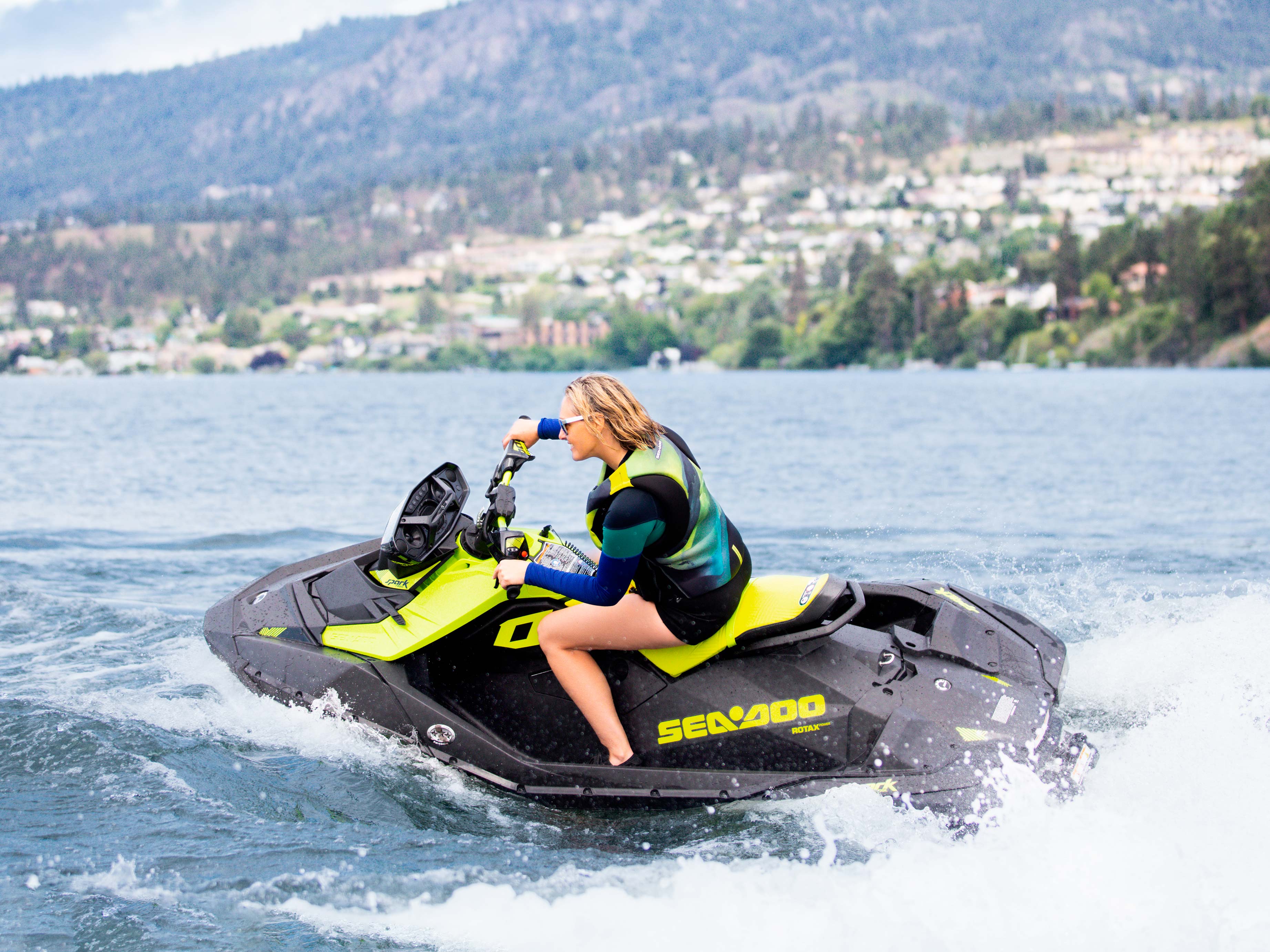 一位女士在骑行带有便携式音响系统的 Sea-Doo SPARK TRIXX 摩托艇